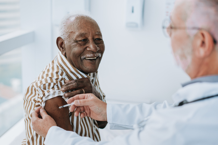 older patient receiving vaccination from health worker